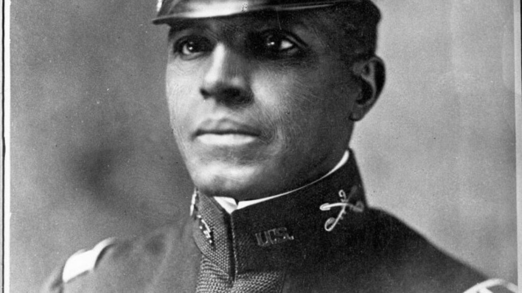 close up of a man in uniform cap and blazer whostares into the distance