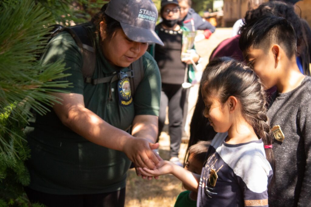 a woman in uniform places something into a small girl's hand