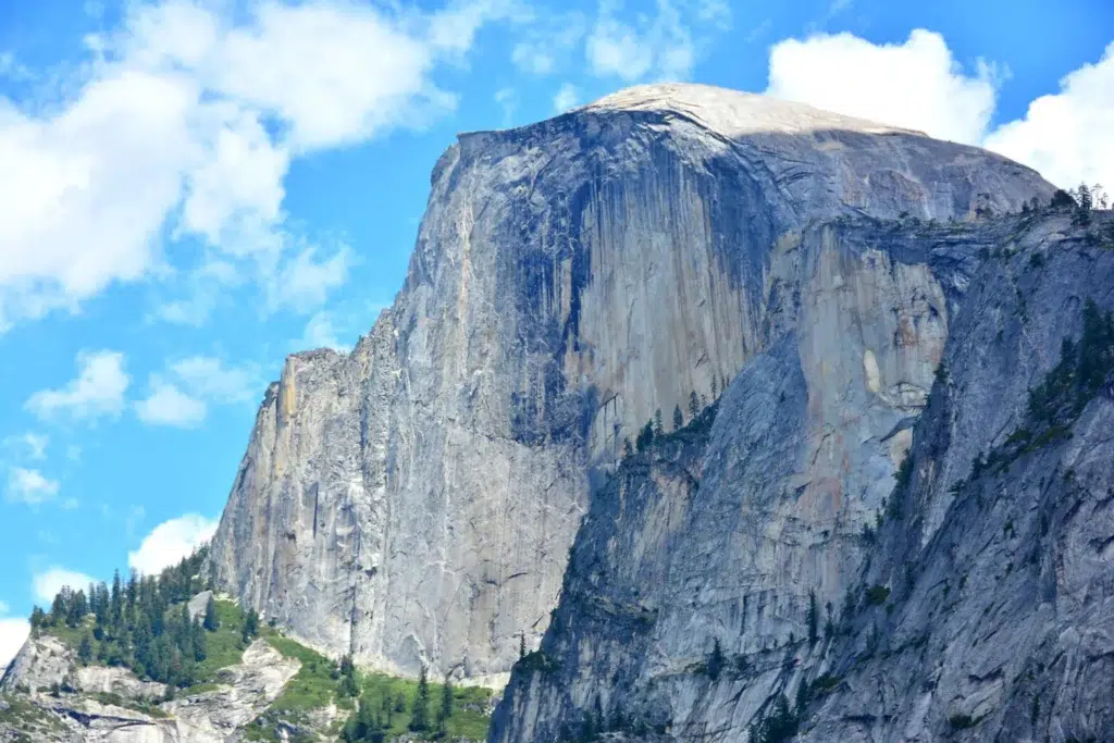 Granite cliff in front of blue sky.