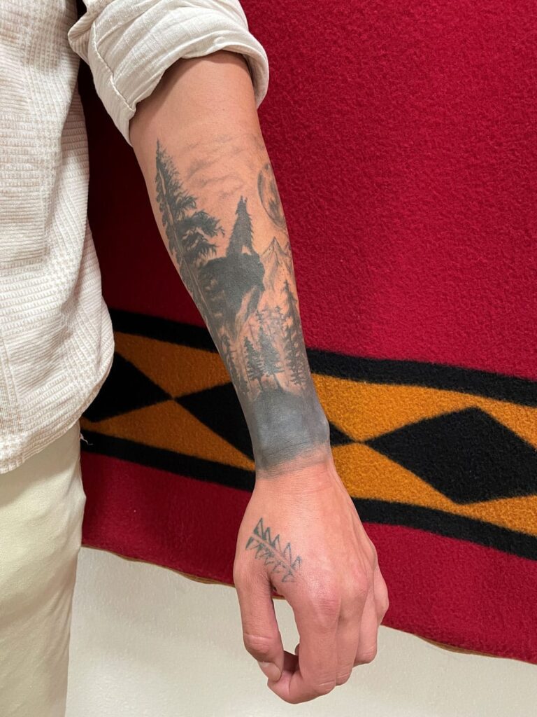 Andrew Sorrell's black and white forearm sleeve tattoo starts at his wrist and extends to his elbow.