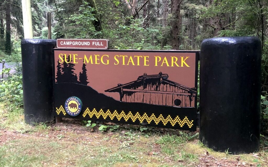 A large brown sign reads "Sue-meg State Park" in yellow letters with a small "campground full" sign above