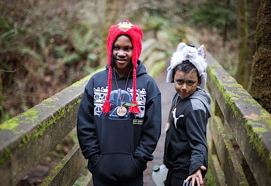 Two kids on a narrow, moss-covered bridge